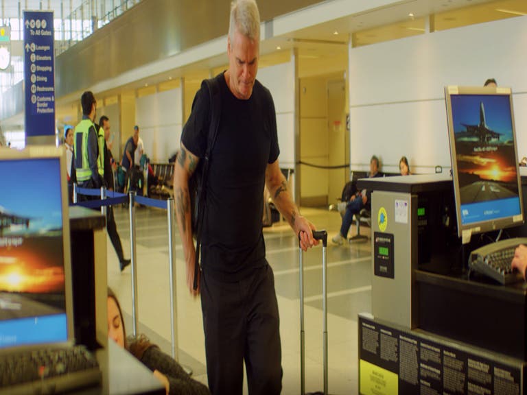 Henry Rollins packs light and weighs his luggage at Tom Bradley International in LAX